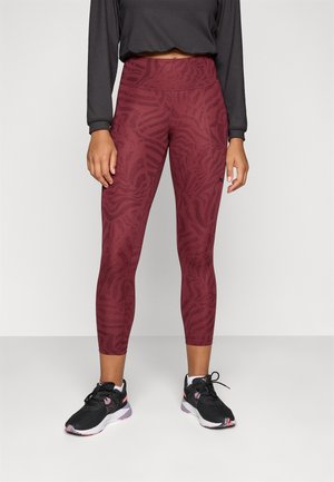 Maroon leggings with a textured animal print, high waistband, and a coordinating dark top. Paired with black athletic shoes.