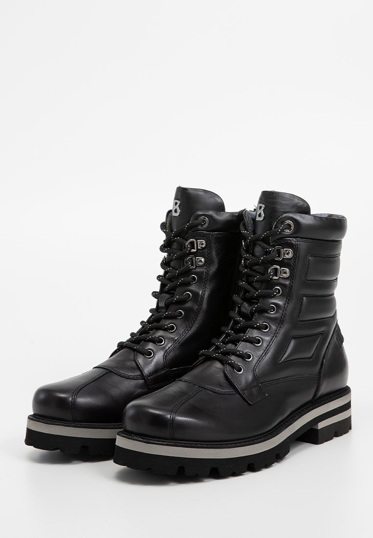 Schwarze Leder Schnürstiefel mit gepolstertem Schaft, Gummisohle mit strukturiertem Grip und dekorativen Seitenpaneelen für gestalterische Details.