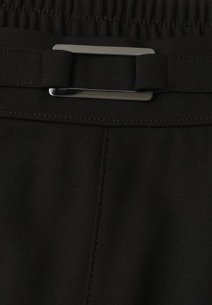 Cinturilla de tela negra con una hebilla metálica rectangular y detalles cosidos a lo largo del borde.