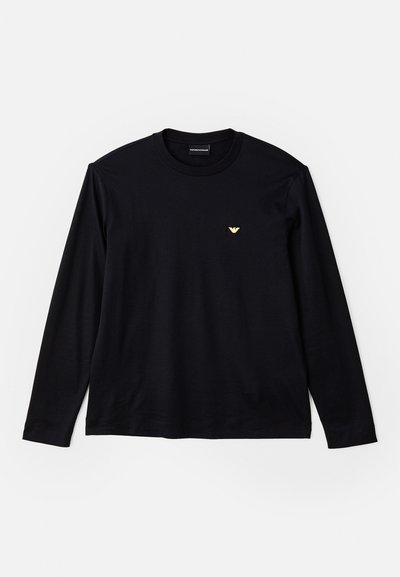 Črn dolgrokavni T-majica, izdelana iz mehke bombažne tkanine, z okruglim izrezom in majhnim zlatim logotipom na prsih.