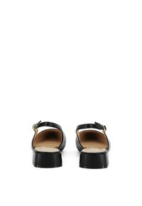 Sandali neri in pelle con retro aperto, cinturino alla caviglia e suola piatta. Presenta una texture liscia e un design minimalista. Dettaglio con fibbia dorata.