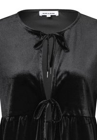 Schwarze Samtjacket mit einer Bindung am Hals, mit glatter Textur und fließendem Schnitt. Etikett besagt "MORE & MORE."