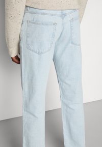 Ljust blå denimjeans med rak passform, med två bakfickor och subtilt blekning. De har en mjuk struktur och en klassisk design.