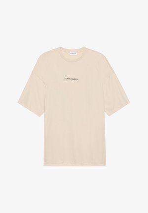 T-shirt en coton beige à coupe décontractée, avec des manches courtes et un col rond. Inscription "Positive Sincere" imprimée en noir sur le devant.