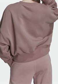 Överdimensionerad, mauve sweatshirt med vid halsringning och långa ärmar; tillverkad av mjukt tyg med en texturerad yta; ribbad nederkant.