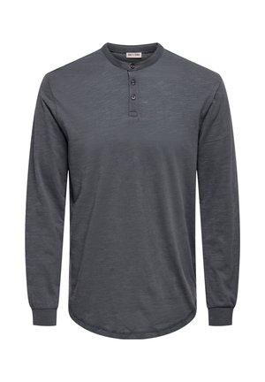 Long-sleeve, gray henley shirt made of soft fabric, featuring a rounded hem, three-button placket, and ribbed cuffs.