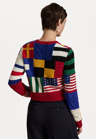 Kootud sviiter, millel on mitmesuguste lippude patchwork erksates värvides, punase ribaga äärise ja palmikutega mustriga.