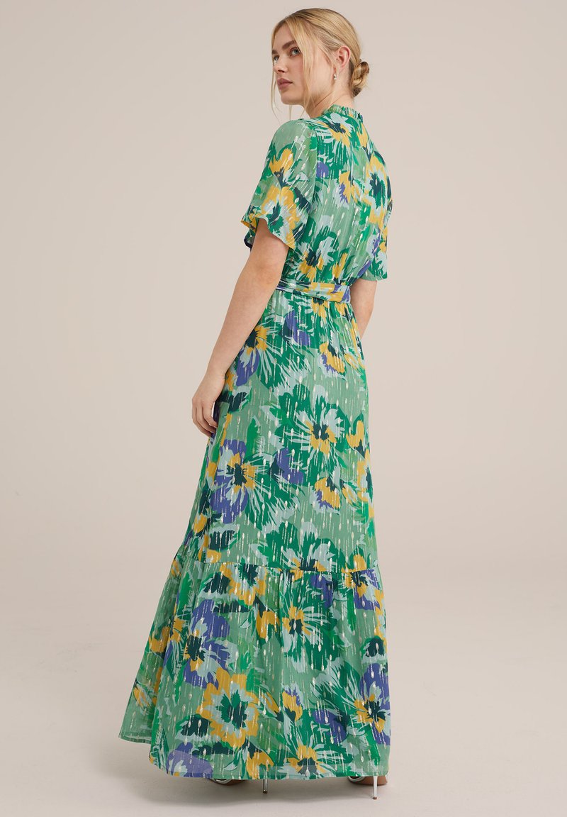 Blumenkleid in Maxilänge in Grün, mit gelben und lila Mustern, kurzen fließenden Ärmeln, einer Taillenschnürung und einem gestuften Rockdesign.