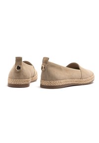 Suede beige espadrilles with a jute rope sole, rounded toe, and a small logo accent on the heel. Smooth texture, casual design.