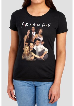 Woman wearing black t-shirt with the TV show Friends cast group photo and the word Friends above them in white letters.
