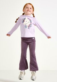 Chemise lilas à manches longues avec un design de licorne en sequins, associée à un pantalon évasé violet en tissu doux. Cœur détaillé sur le pantalon.