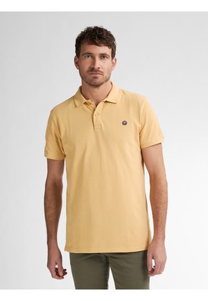 Camisa polo de algodón amarilla con cuello, mangas cortas y un logo en el pecho. Textura de punto liso y dobladillo recto con aberturas laterales.