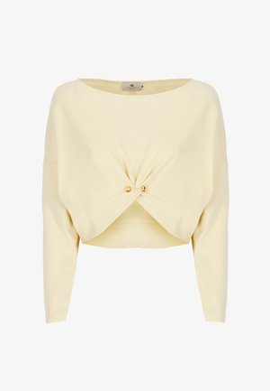 Top giallo corto realizzato in tessuto liscio, con scollo a barca, maniche lunghe e un dettaglio frontale intrecciato accentuato da hardware dorato.