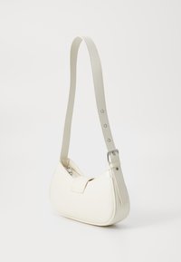Sac à main synthétique blanc avec une forme arrondie, une bandoulière ajustable et une texture lisse. Doté d'un rabat avant et d'accents en métal argenté.