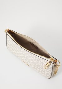 Borsa a tracolla beige con hardware dorato, dotata di chiusura a zip e motivo con logo. L'interno è foderato, presentando una texture liscia.