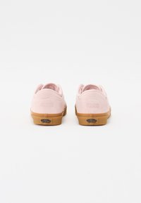 Sneakers basse in suede rosa con suola in gomma, caratterizzate da numeri in rilievo 66/99 sul tallone e il marchio "VANS OFF THE WALL" sulla parte inferiore.