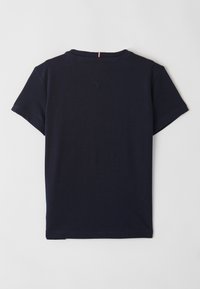 Marineblauwe katoenen T-shirt met korte mouwen, ronde hals en een subtiele driehoekige accent aan de achterkant. Gladde textuur, minimaal ontwerp.