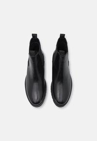 Czarne skórzane botki za kostkę z elastycznymi panelami bocznymi, okrągłym noskiem i pętelką z tyłu. Gładka powierzchnia i trwała podeszwa.