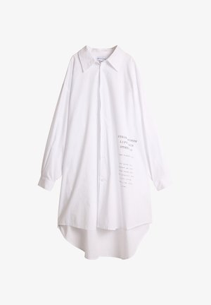 Hvit skjorte med krage, lange ermer og høy-lav hem. Har trykt tekst foran i grått. Myk stofftekstur.