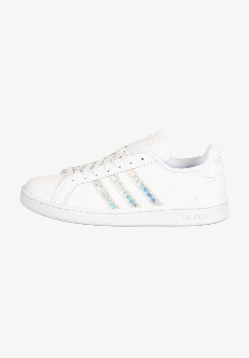 Baskets basses blanches Adidas avec trois bandes irisées, lacets, et logo embossé sur la semelle en caoutchouc et la languette du talon.