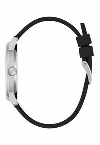 Srebrna okrągła koperta zegarka z czarnym gumowym paskiem. Widok boczny ukazuje okrągłą koronę i mechanizm zapięcia, podkreślając smukły design.