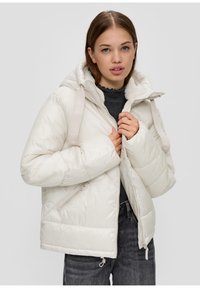 Padded ivory jacket with a hood, featuring smooth texture, zip closure, and two side pockets. Accented with branding on straps.
