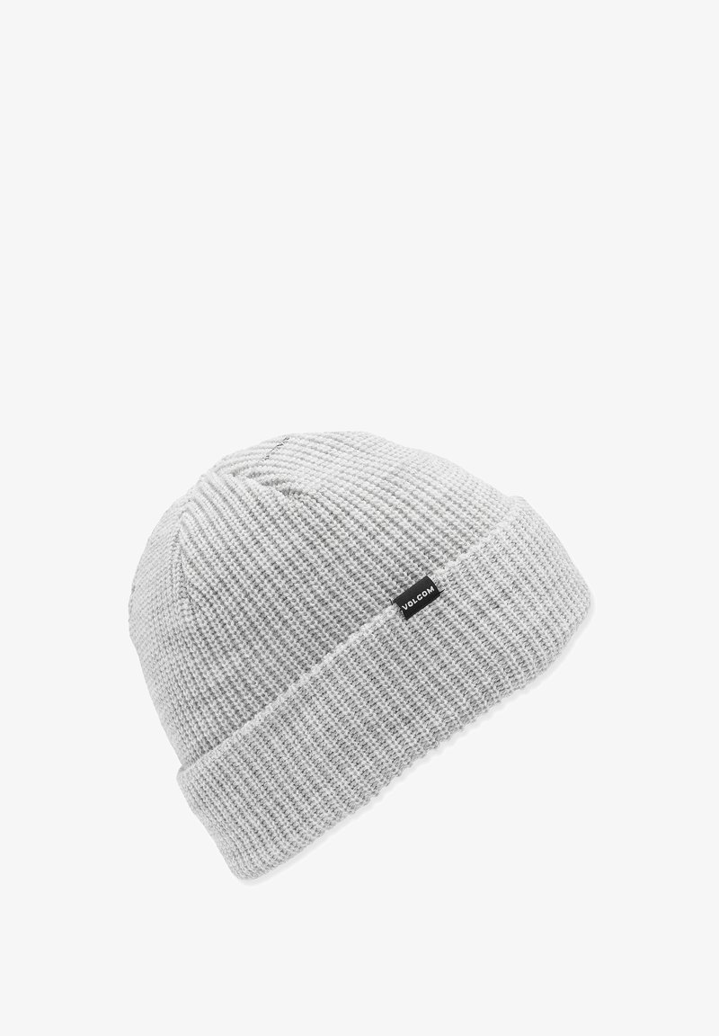 Bonnet en tricot gris avec une texture côtelée, présentant un revers replié et une petite étiquette logo noire sur le côté.