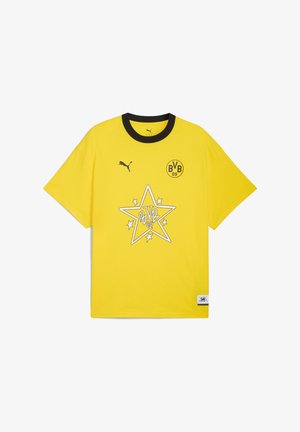 Kollane puuvillane T-särk musta kraega, millel on täht graafika ja 'BVB 09' logo. Lühikesed varrukad, lõdvestatud lõige, tekstuuriga kangas.