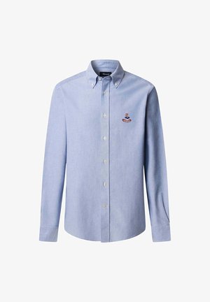 Camicia azzurra a maniche lunghe con colletto abbottonato e un piccolo stemma ricamato sul lato sinistro del petto.