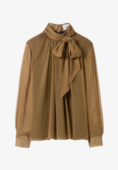 Blusa marrón, transparente, con cuello alto y lazo. Presenta un patrón de lunares, mangas largas y un diseño plisado.