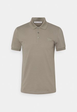 Polo shirt kaki en tissu lisse, avec une patte de boutonnage à trois boutons, des manches courtes et un petit logo brodé sur la poitrine.