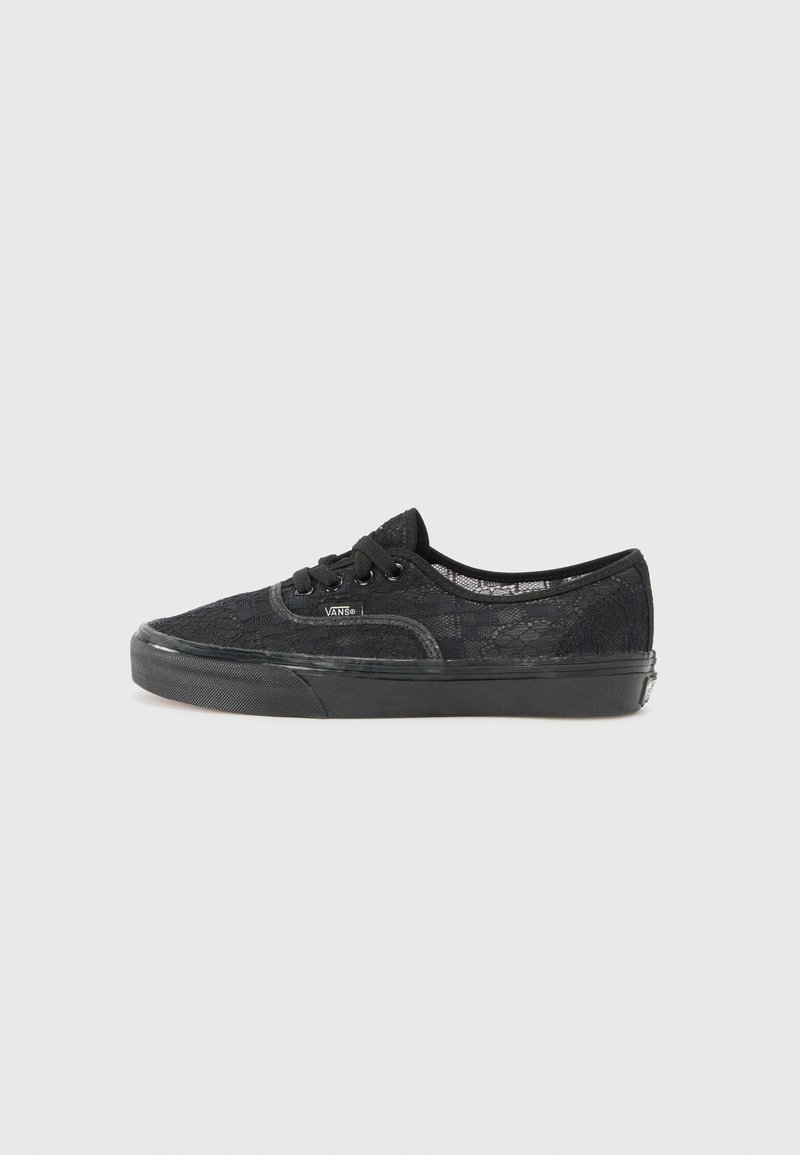 Fekete csipkeborítású sneaker fekete gumitalppal, kerek orral és fekete fűzőkkel. Jellemzője a texturált csipkeborítás és a diszkrét márkázás az oldalon.