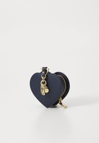 Marineblaues, herzförmiges Leder-Münzfach mit goldenem Reißverschluss und Schlüsselring. Glatte Textur mit minimalen Akzenten und kompaktem Design.