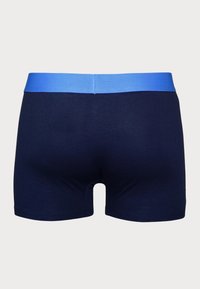 Marineblaue Boxershorts mit einem hellblauen elastischen Bund. Glatte Textur und figurbetontes Design, mit einem mittelhohen Schnitt.