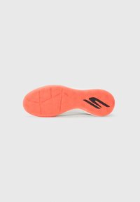 Shoe sole with a wavy tread pattern, orange rubber color, and a black logo accent. Smooth edges with a slight curve for ergonomic design.