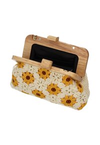 Bolso de mano tejido al crochet con un patrón floral en amarillo y crema, cierre de madera y forro interior negro. Forma rectangular.