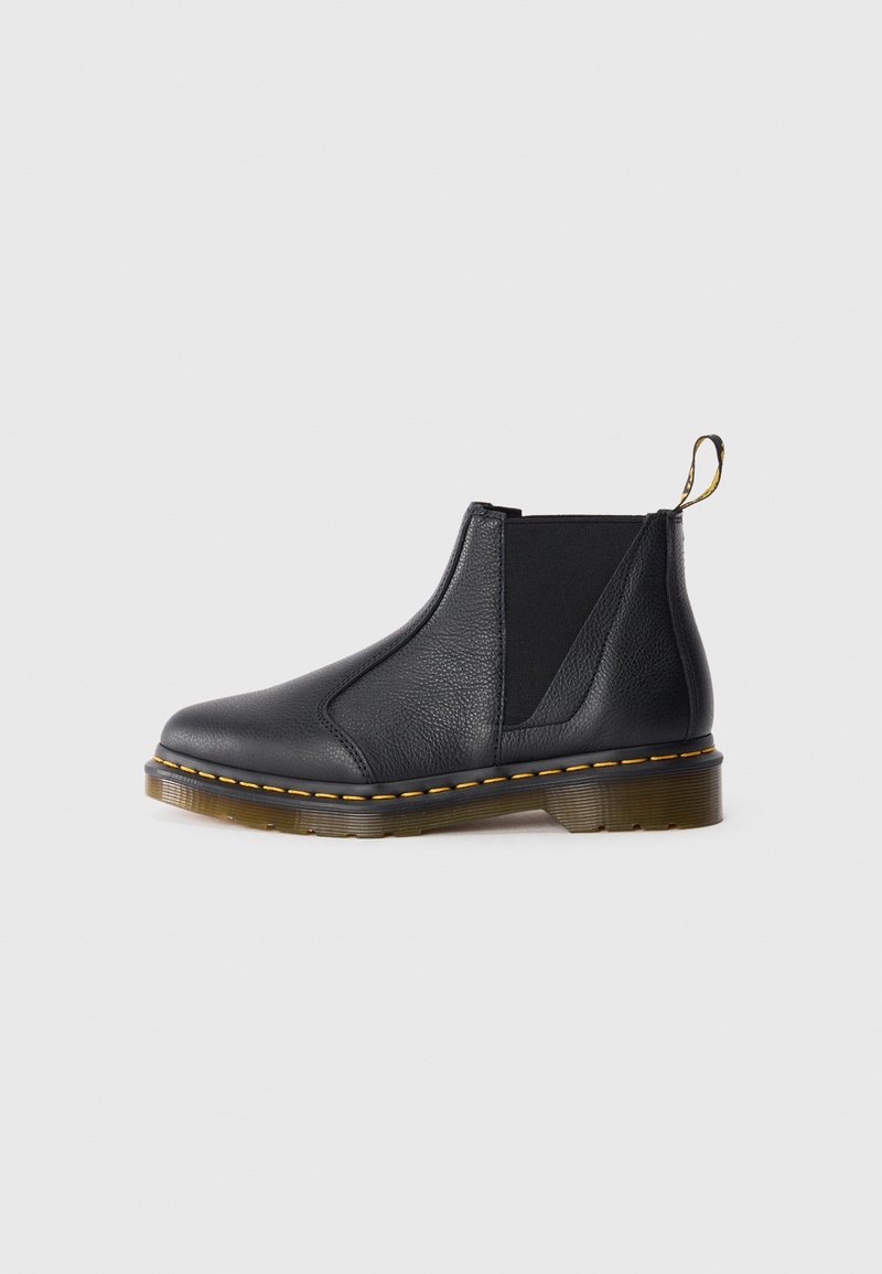 Botte Chelsea en cuir noir avec panneaux latéraux élastiques, couture jaune sur la semelle et un onglet à l'arrière.