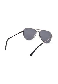 Metalowe okulary pilota z ciemnoszarymi soczewkami. Srebrna oprawa z czarnymi końcówkami zauszników i poduszkami na nos. Lekka konstrukcja, elegancka i minimalistyczna.