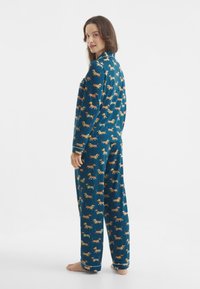 Blaues Flanell-Pyjama-Set mit einem wiederholten Dackel-Muster. Langärmlig, lockere Passform, mit Bündchen und Hosen, die dem Muster des Shirts entsprechen.