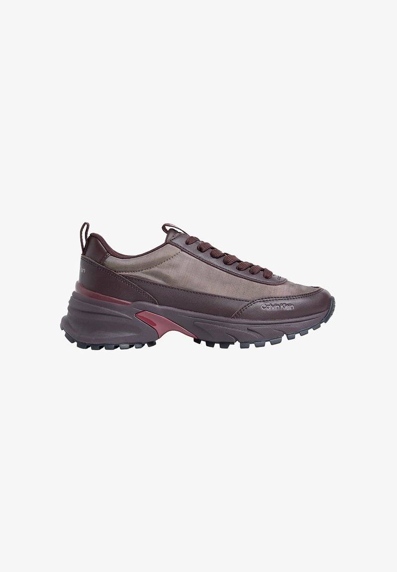 Baskets basses marron Calvin Klein avec semelle épaisse, bout lacé et détail de marque près de l'orteil, vues de profil sur fond blanc.