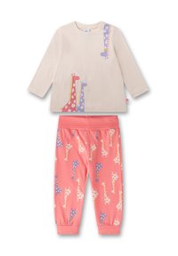 Helle beige Langarmshirt mit bunten Giraffenprints; korallenfarbene Hose mit wiederholtem Giraffenmuster; Baumwollmaterial; entspannter Schnitt.