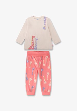 Helle beige Langarmshirt mit bunten Giraffenprints; korallenfarbene Hose mit wiederholtem Giraffenmuster; Baumwollmaterial; entspannter Schnitt.