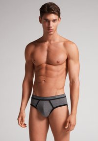 Grijze katoenen boxershorts met zwarte accenten, geconformeerde voorkant en een logo tailleband. Soepele textuur en strakke ontwerp voor een comfortabele pasvorm.