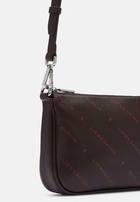 Czarna skórzana nerka w kolorze ciemnego brązu z czerwonym wzorem tekstowym "Liebeskind Berlin", srebrnym zamkiem błyskawicznym oraz odczepianym skórzanym paskiem z metalowym zapięciem.