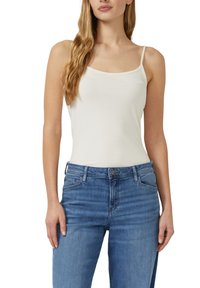 Biały top na cienkich ramiączkach, zestawiony z jasnoniebieskimi dżinsami. Materiał wygląda na gładki i dopasowany, podkreślając prosty design.