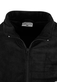 Jachetă din fleece neagră cu guler înalt și fermoar pe toată lungimea. Textură moale cu un luciu subtil. Eticheta interioară vizibilă la guler.