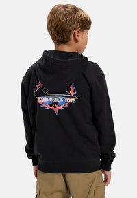 C sweatshirt preto com um design de chamas coloridas e um logo nas costas. O material é suave com um corte relaxado, e inclui um capuz com cordão.