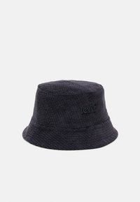 Ciemnoniebieska, kordurojowa czapka typu bucket z szerokim brzegiem i teksturowanym wykończeniem, z subtelnym haftowanym logo z boku. Trwały i casualowy design.