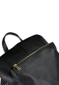 Zwarte leren rugzak met een gestructureerd oppervlak, voorzien van een gouden rits en een enkele schouderband. Eenvoudige, rechthoekige vorm met een voorvak.