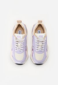 Sneakers viola e crema con pannelli in rete, suole in gomma testurizzata e lacci bianchi. Presentano un logo discreto sulla linguetta e sul lato.